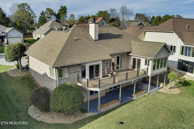 back of house featuring a lawn, a deck, and a patio