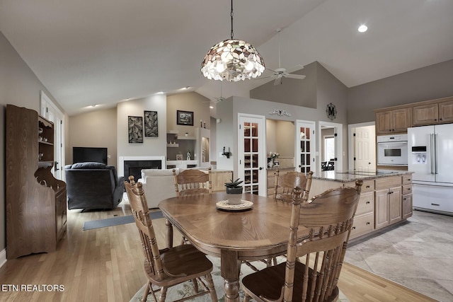 dining room featuring french doors, light hardwood / wood-style floors, high vaulted ceiling, and ceiling fan