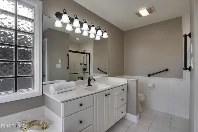 full bathroom with plus walk in shower, tile patterned floors, toilet, vanity, and tile walls