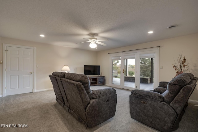 carpeted living room with a textured ceiling and ceiling fan