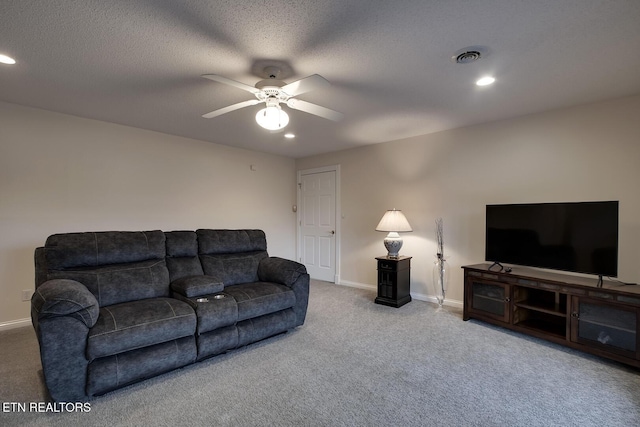 living room featuring a textured ceiling, carpet floors, and ceiling fan