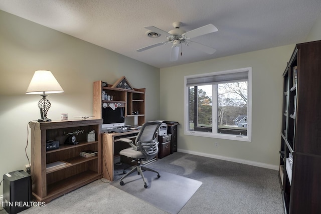 carpeted office space with a textured ceiling and ceiling fan