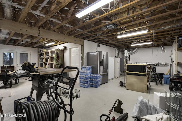 basement featuring stainless steel fridge with ice dispenser, a workshop area, and water heater