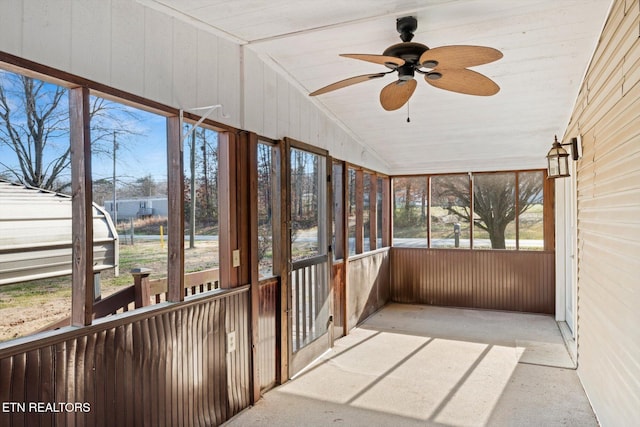 unfurnished sunroom featuring ceiling fan, plenty of natural light, and lofted ceiling