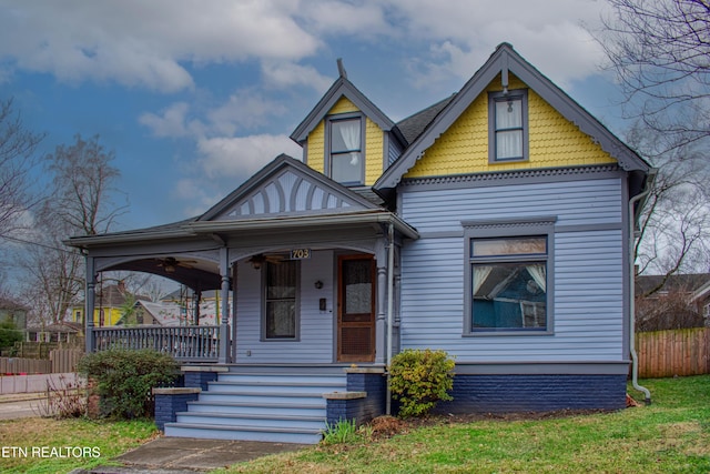 victorian house with a porch and a front yard