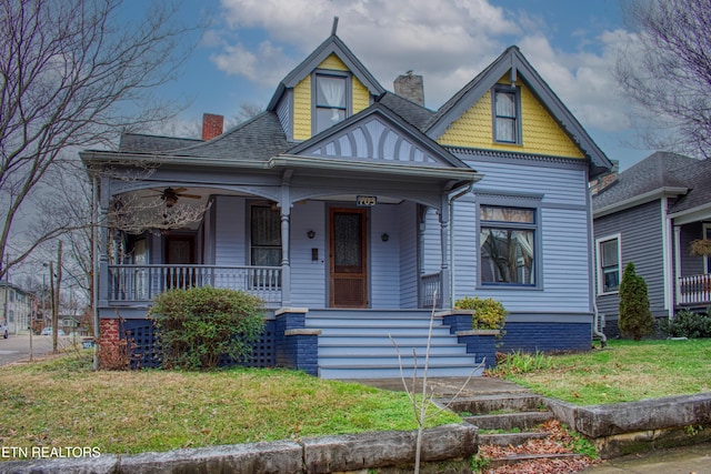 victorian-style house featuring a porch and a front lawn