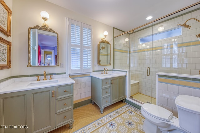 bathroom featuring tile patterned floors, vanity, an enclosed shower, and tile walls