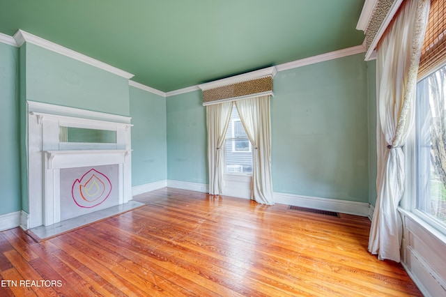 unfurnished living room featuring light hardwood / wood-style floors and crown molding