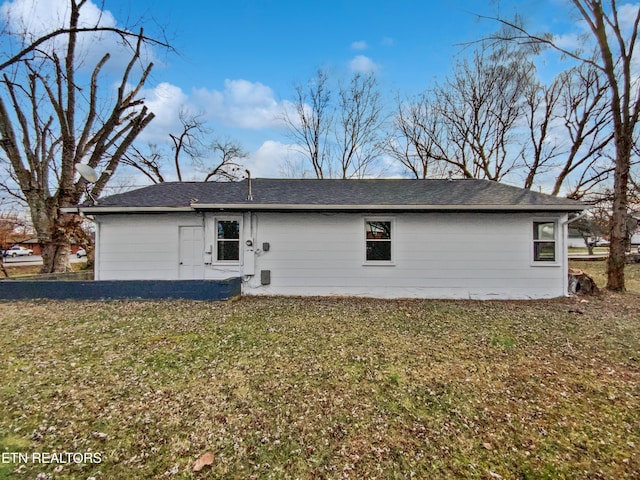 rear view of house featuring a lawn