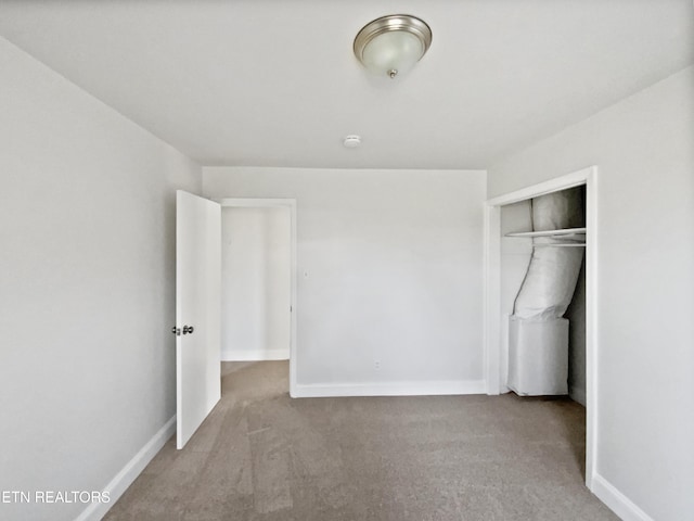 unfurnished bedroom with light carpet and a closet