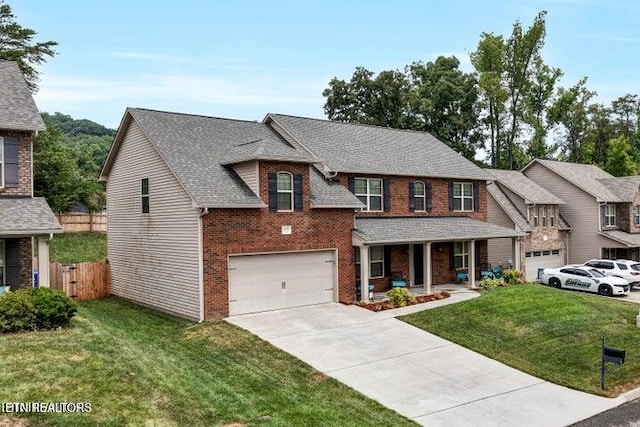 view of front of home featuring covered porch, a garage, and a front yard