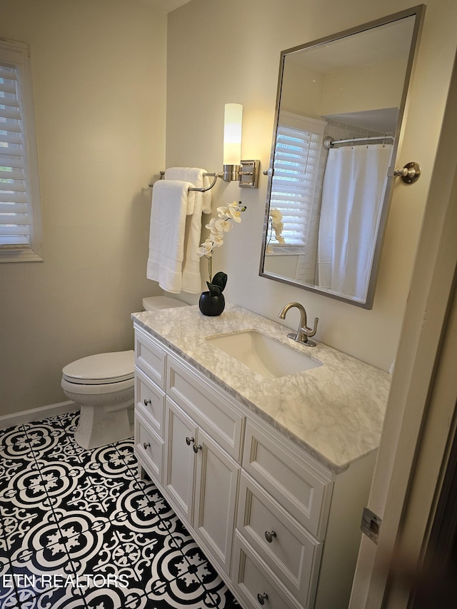 bathroom with a shower with curtain, tile patterned flooring, vanity, and toilet