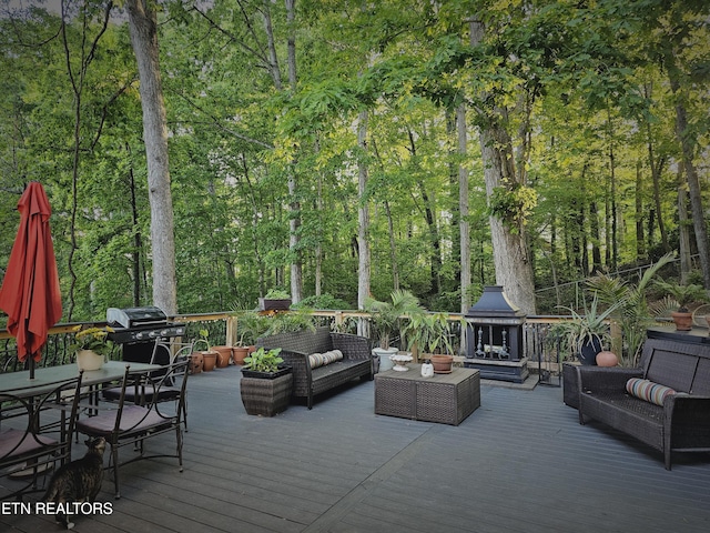 wooden terrace featuring area for grilling and an outdoor living space