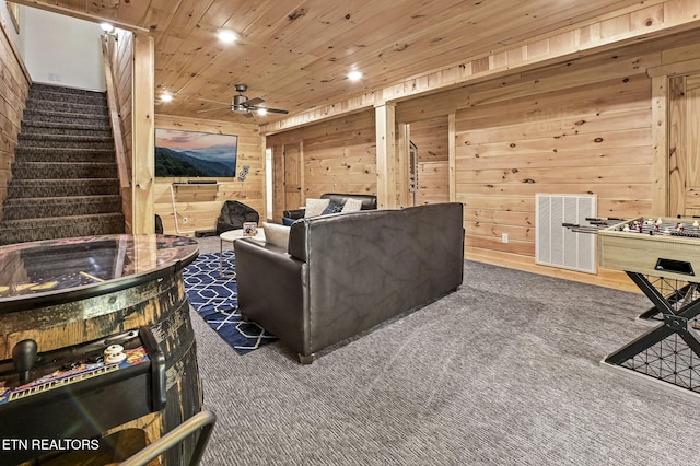 home theater featuring dark colored carpet, ceiling fan, wooden ceiling, and wooden walls