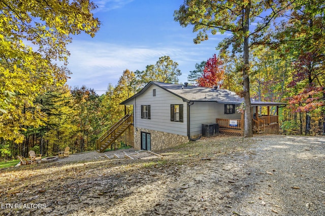 view of side of property with central AC unit and a wooden deck