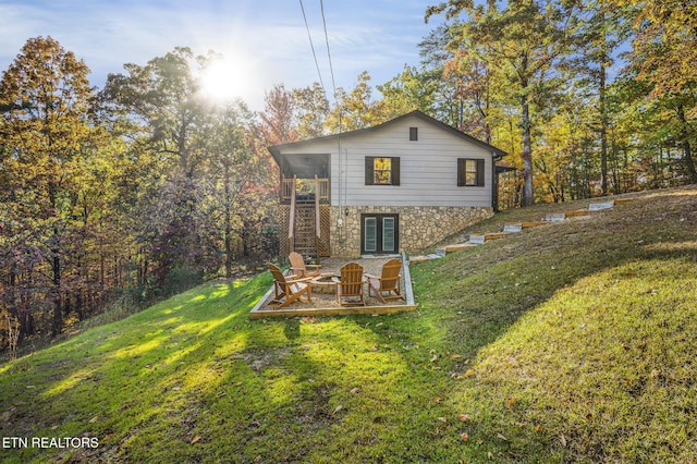 back of property with a patio area, a yard, and an outdoor fire pit