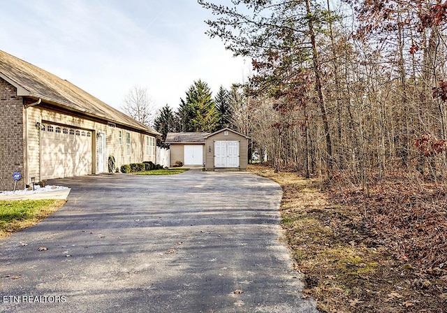 view of side of home featuring a storage unit and a garage