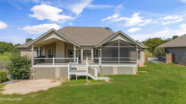 back of property with a sunroom and a yard