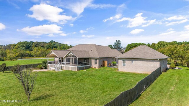 view of front of home featuring a sunroom and a front yard