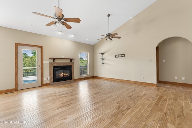 unfurnished living room with ceiling fan, a healthy amount of sunlight, light wood-type flooring, and a fireplace