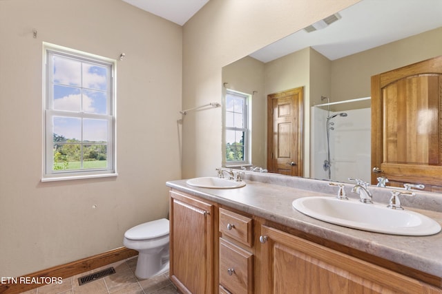 bathroom with tile patterned flooring, toilet, vanity, and walk in shower