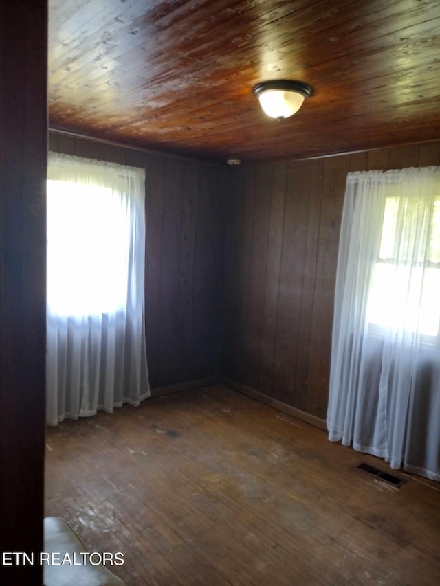 spare room with wood-type flooring, plenty of natural light, and wood ceiling