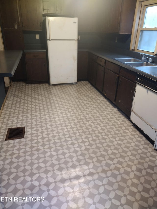 kitchen featuring sink, white appliances, and dark brown cabinets