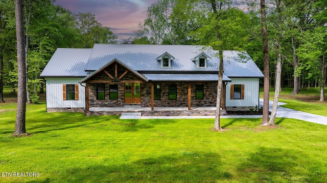 view of front of property featuring metal roof, a front yard, crawl space, and covered porch