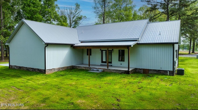 back of property featuring a yard, covered porch, metal roof, central air condition unit, and crawl space