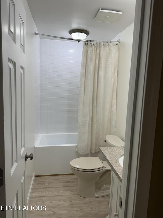 full bathroom with shower / bathtub combination with curtain, vanity, wood-type flooring, and toilet