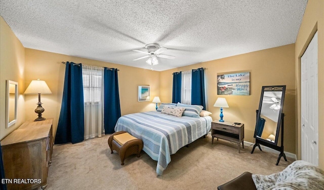 carpeted bedroom with a textured ceiling, a closet, and ceiling fan