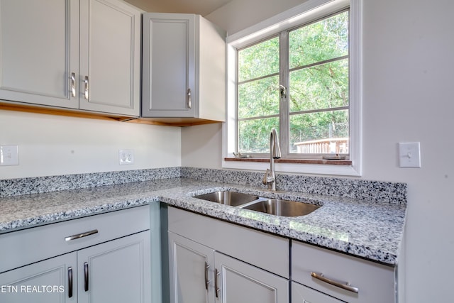 kitchen with light stone counters and sink