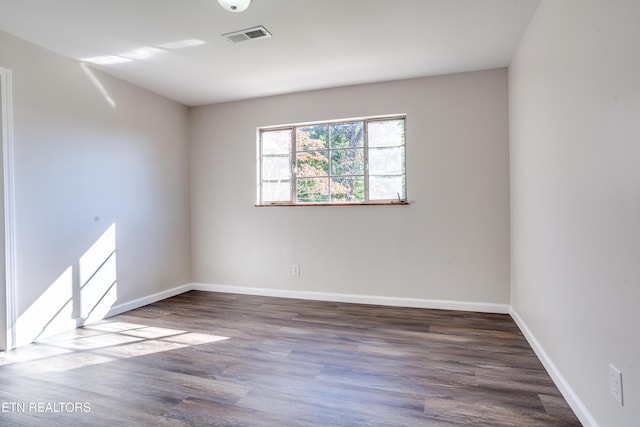 spare room with dark wood-type flooring