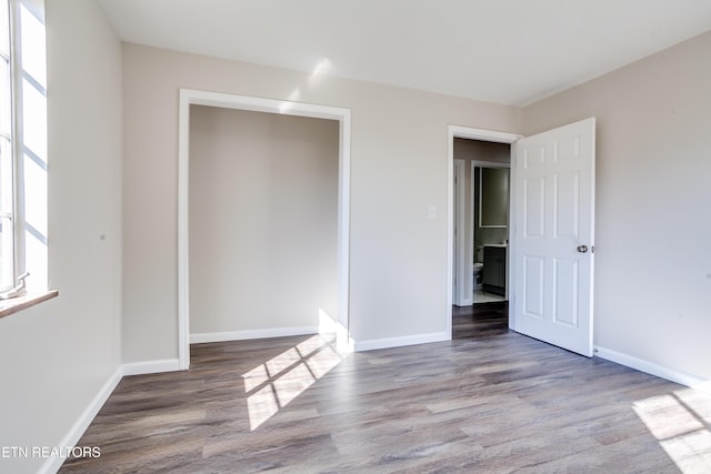 unfurnished bedroom featuring a closet and hardwood / wood-style floors