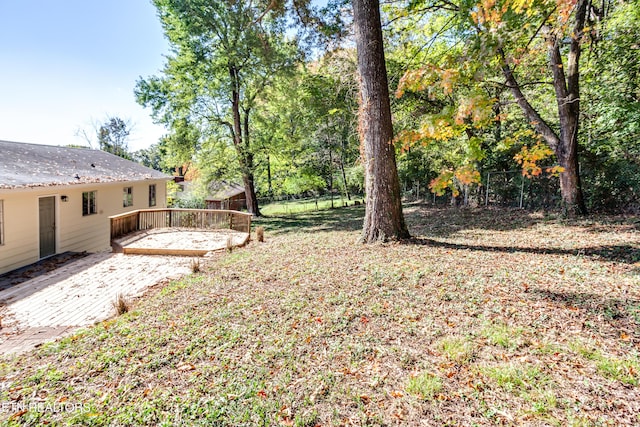 view of yard featuring a wooden deck and a patio