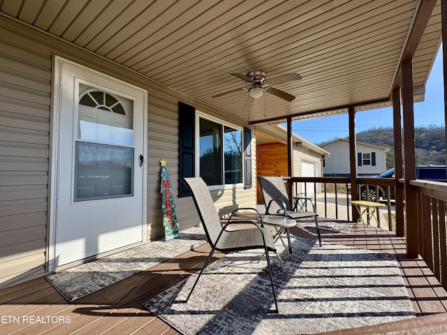 wooden deck with a porch and ceiling fan