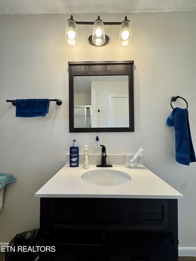 bathroom featuring a textured ceiling and vanity