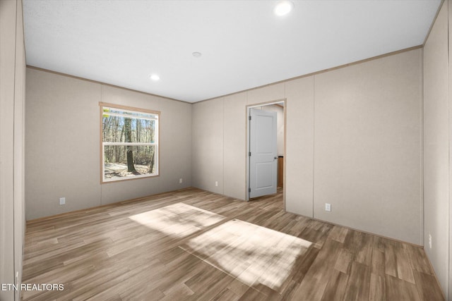 unfurnished room featuring light hardwood / wood-style floors and crown molding