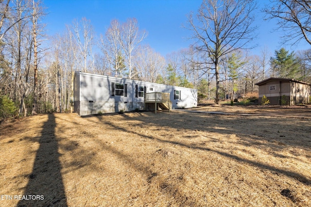 manufactured / mobile home with a deck and a front lawn