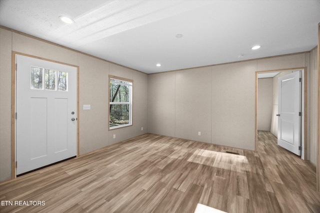 foyer entrance featuring light hardwood / wood-style flooring and a textured ceiling