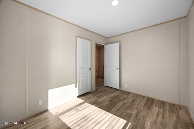 unfurnished bedroom featuring ornamental molding and hardwood / wood-style flooring