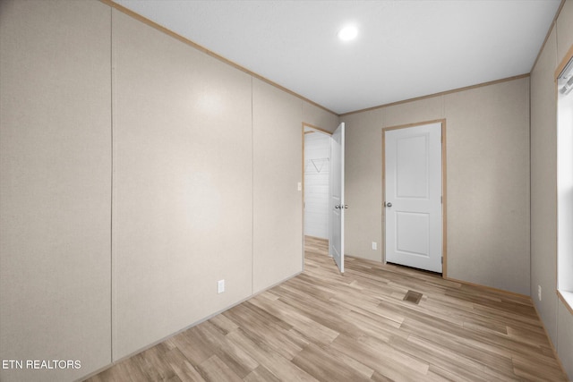 spare room with crown molding and light hardwood / wood-style flooring