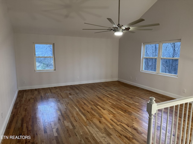 empty room with ceiling fan, dark hardwood / wood-style flooring, and lofted ceiling