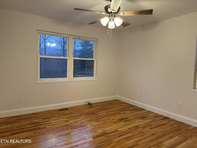 empty room with ceiling fan and dark hardwood / wood-style floors