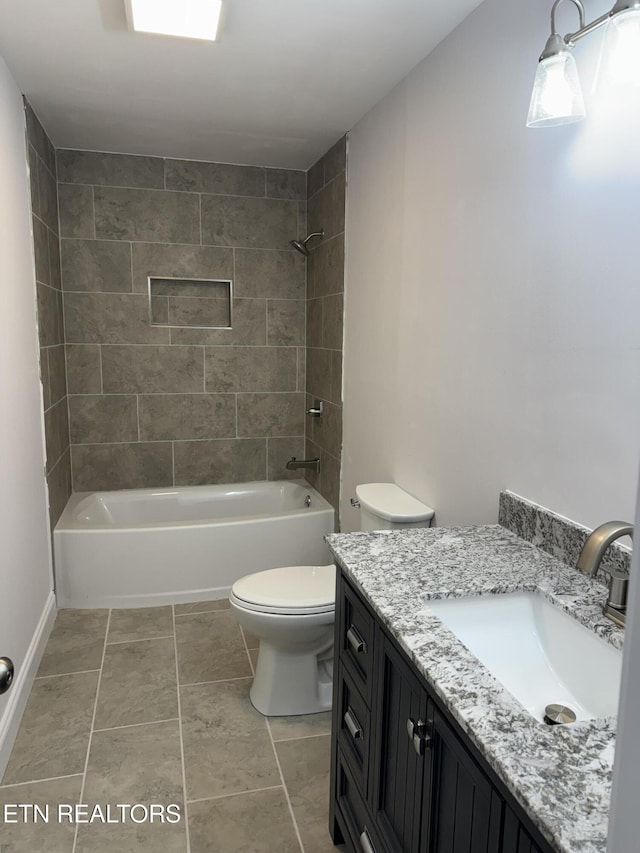 full bathroom featuring tile patterned floors, vanity, tiled shower / bath combo, and toilet