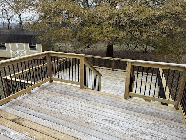 wooden terrace featuring a shed