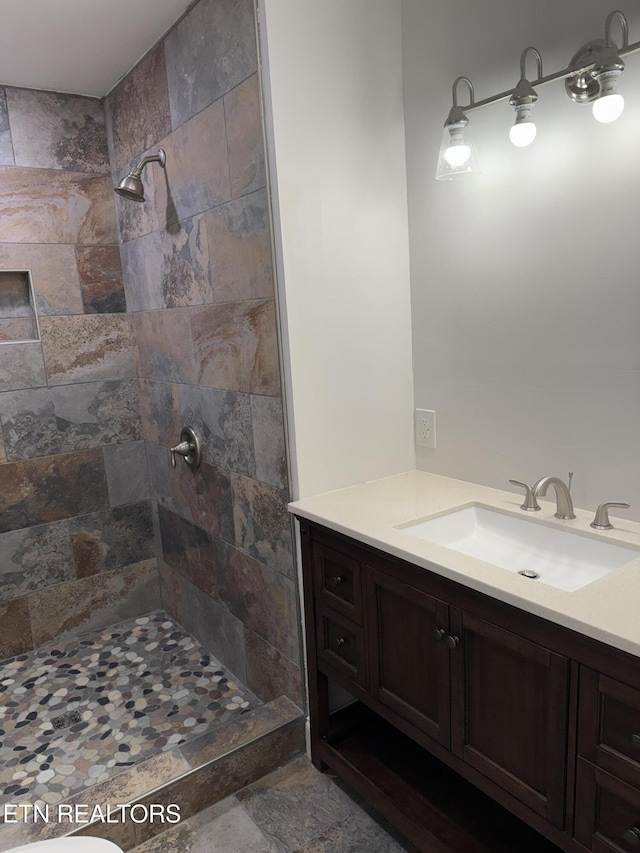 bathroom featuring vanity and tiled shower