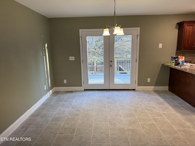 doorway with french doors, light tile patterned floors, and a chandelier