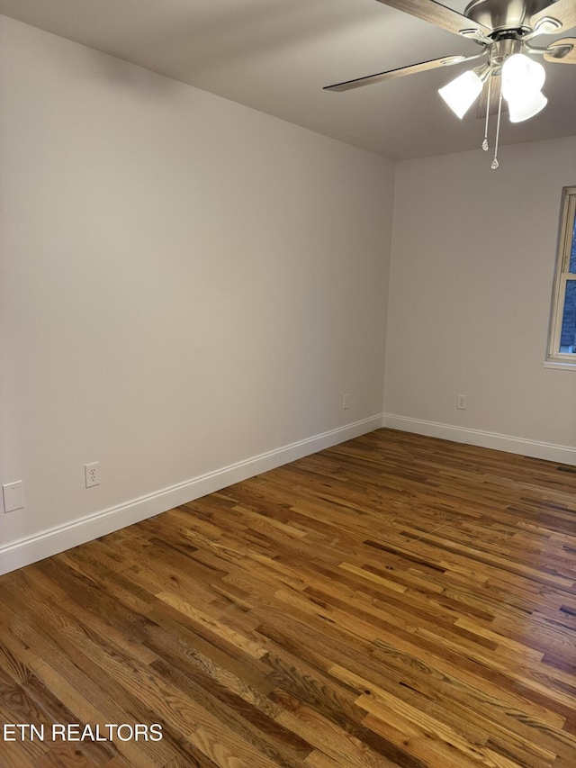 spare room with dark hardwood / wood-style flooring and ceiling fan