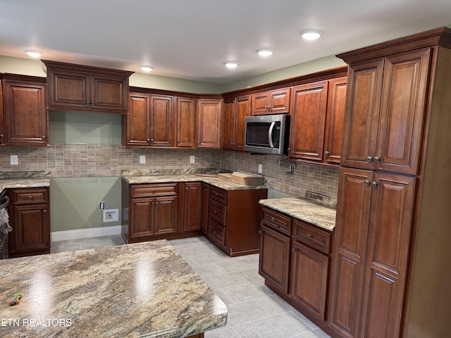 kitchen featuring tasteful backsplash and light stone counters